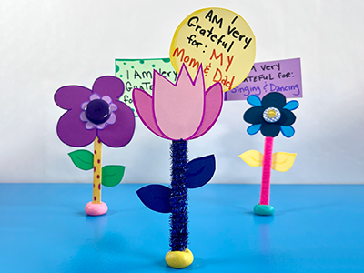 Paper flowers with notes of gratitude attached to them.