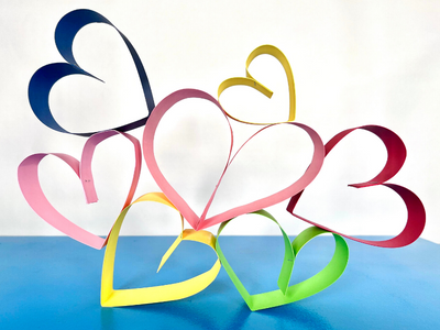 Several hearts made out of paper stripes are glued together and stand upright