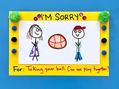 A hand-drawn card with equins and pom poms that contains an apology